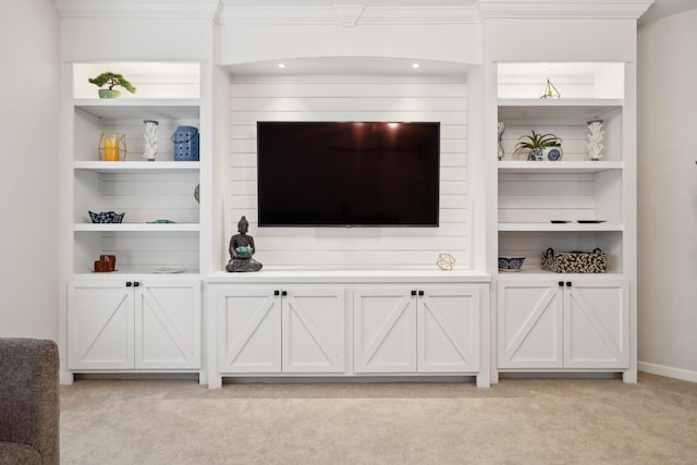 carpeted living room with ornamental molding and built in features