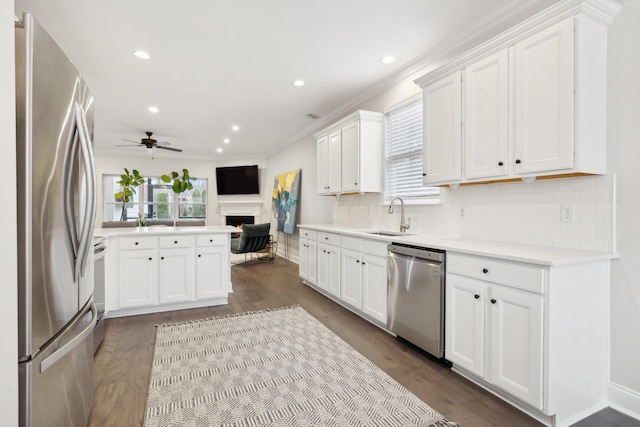 kitchen featuring sink, appliances with stainless steel finishes, tasteful backsplash, white cabinets, and kitchen peninsula