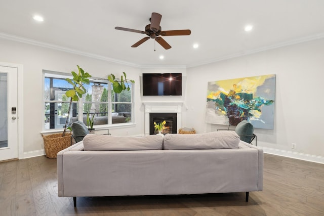 living room with crown molding, ceiling fan, and dark hardwood / wood-style flooring