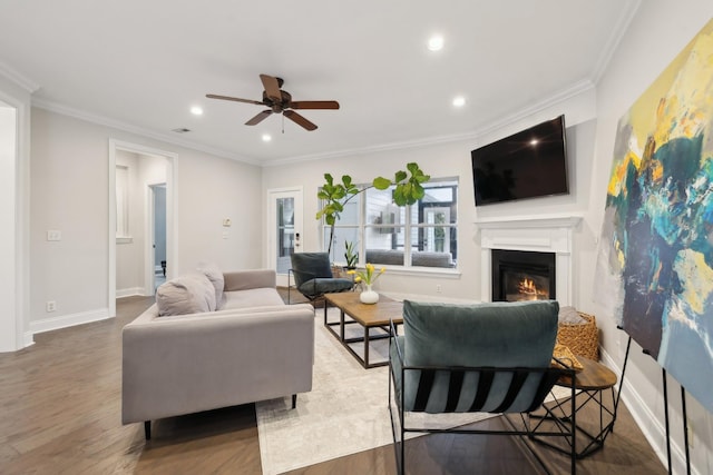 living room featuring ceiling fan, ornamental molding, and dark hardwood / wood-style flooring