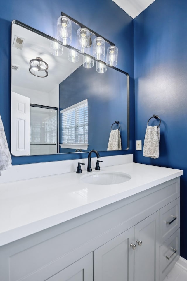 bathroom featuring vanity and a shower with shower door