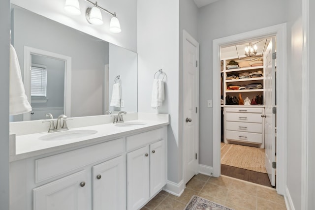 bathroom with tile patterned flooring, vanity, and a notable chandelier