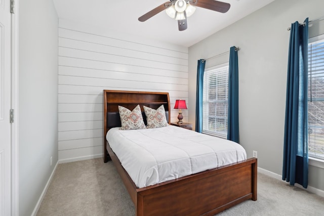 carpeted bedroom featuring multiple windows and ceiling fan