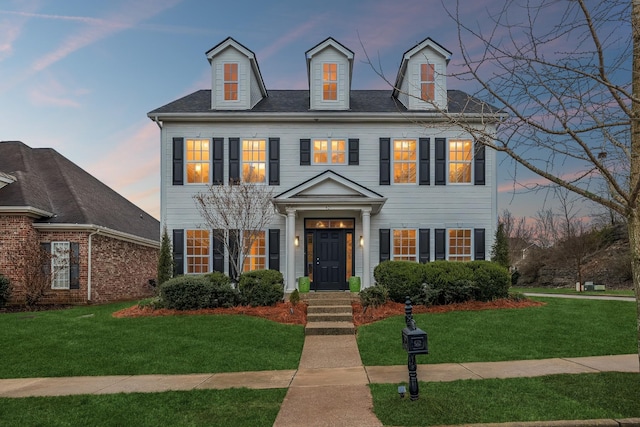 colonial inspired home with a lawn