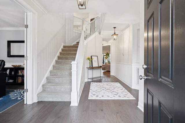 entrance foyer featuring crown molding and dark wood-type flooring