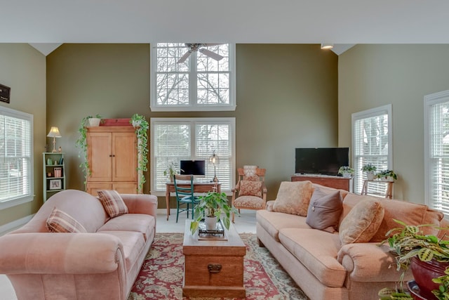 living room featuring ceiling fan and a towering ceiling