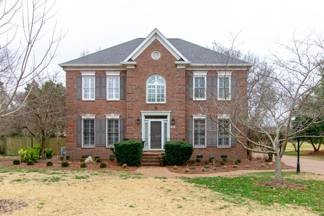 colonial inspired home featuring a front lawn