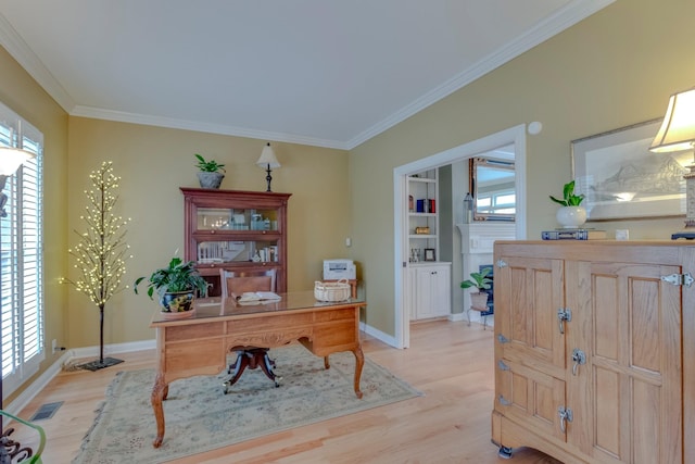 office area with ornamental molding, light hardwood / wood-style floors, and a healthy amount of sunlight