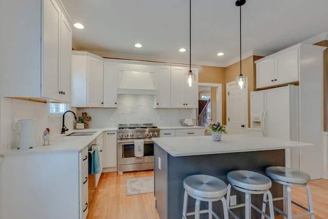 kitchen featuring sink, stainless steel stove, a center island, custom range hood, and white cabinets