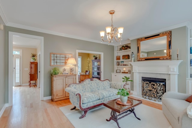 living room featuring crown molding, built in shelves, an inviting chandelier, and light hardwood / wood-style flooring