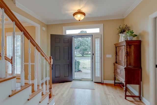 foyer entrance featuring light hardwood / wood-style flooring, crown molding, and plenty of natural light