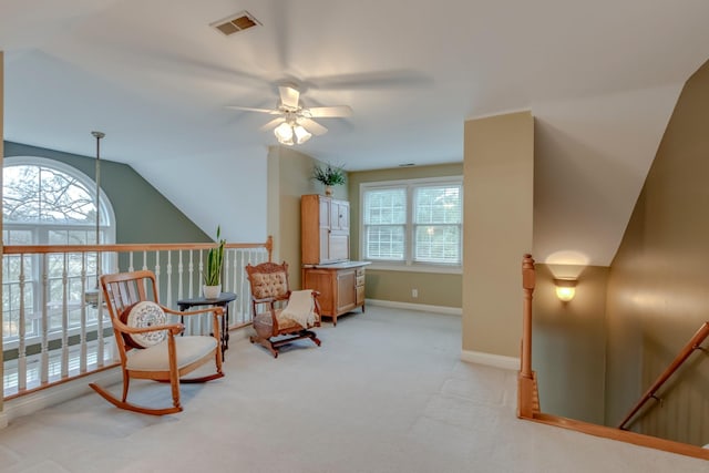 living area featuring a wealth of natural light, lofted ceiling, light carpet, and ceiling fan