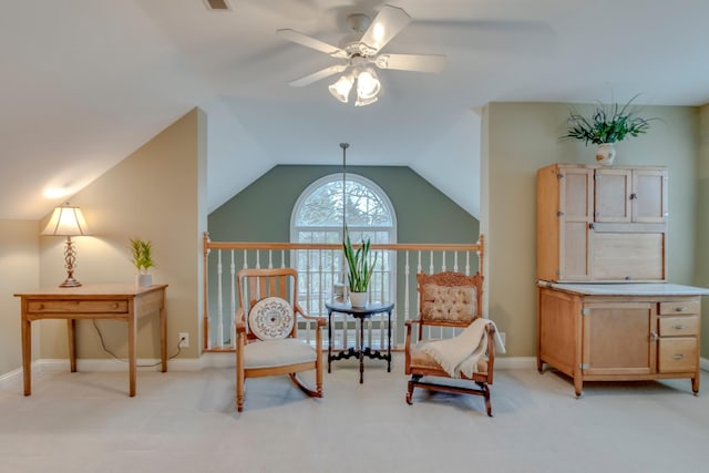 living area featuring ceiling fan, light colored carpet, and lofted ceiling