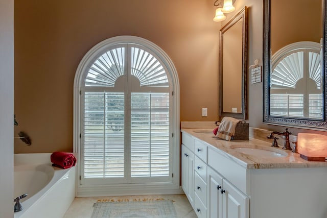 bathroom featuring vanity, tile patterned flooring, plenty of natural light, and a tub