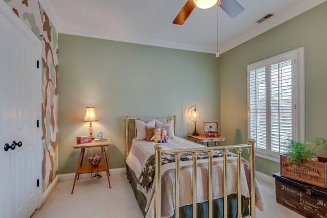 carpeted bedroom featuring ornamental molding and ceiling fan