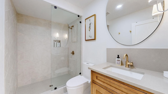 bathroom featuring tiled shower, vanity, and toilet