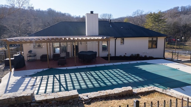 back of house featuring a swimming pool side deck