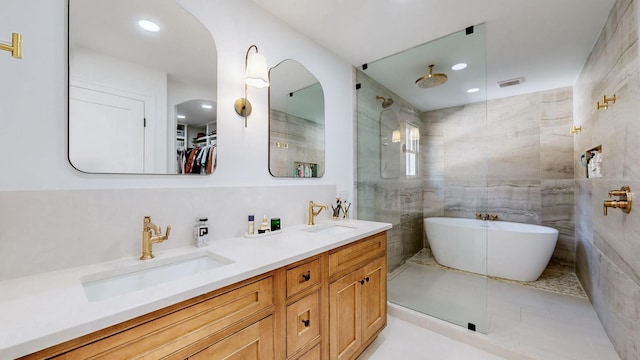 bathroom featuring vanity, separate shower and tub, tile patterned flooring, and tile walls