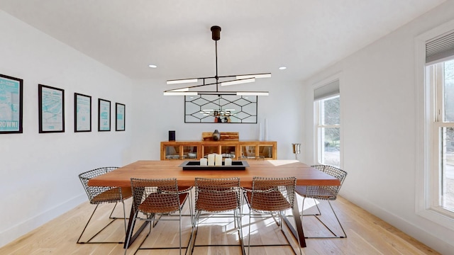 dining area featuring light hardwood / wood-style flooring, plenty of natural light, and a chandelier