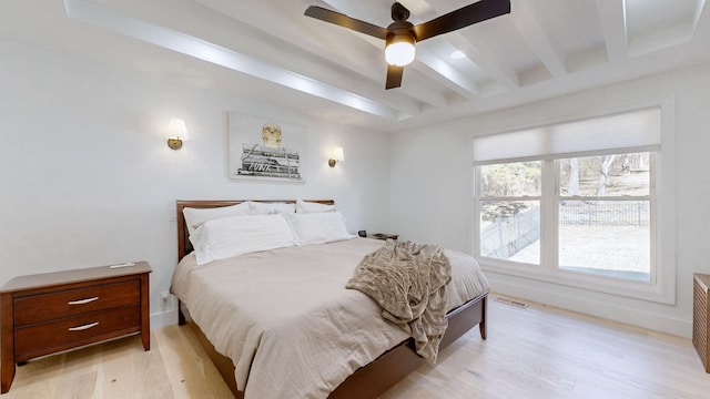 bedroom with ceiling fan, light hardwood / wood-style flooring, and beamed ceiling