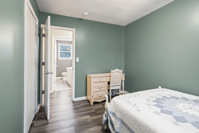 bedroom with dark hardwood / wood-style floors and a textured ceiling