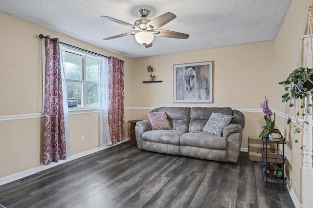 living room with ceiling fan, dark hardwood / wood-style flooring, and a textured ceiling