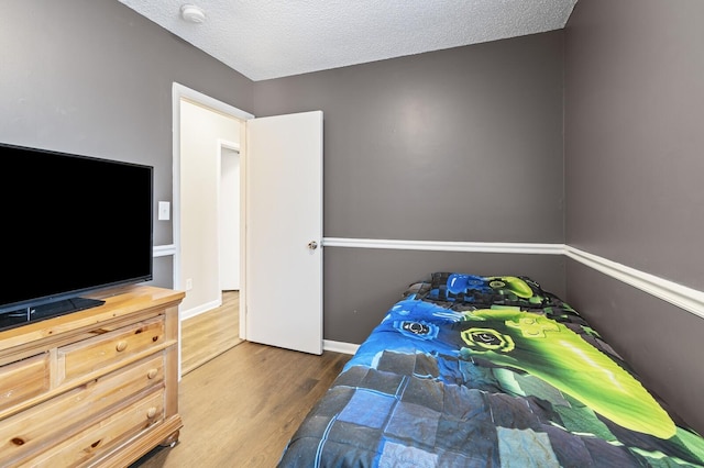 bedroom with dark wood-type flooring and a textured ceiling