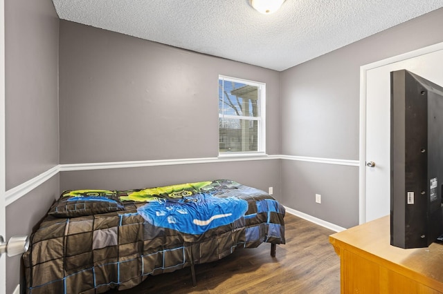 bedroom with wood-type flooring and a textured ceiling