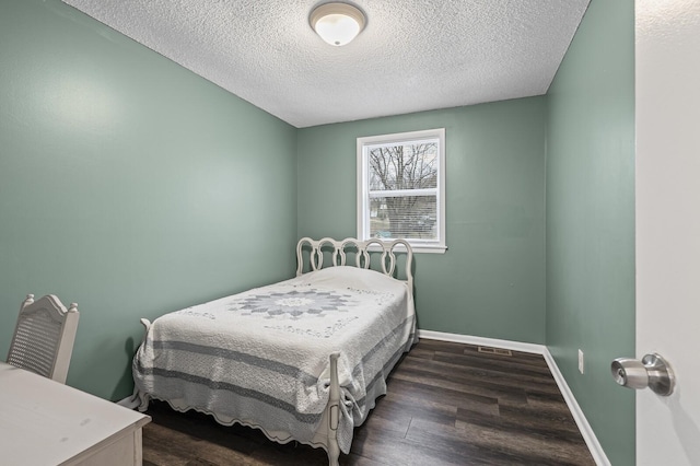 bedroom featuring dark hardwood / wood-style floors and a textured ceiling