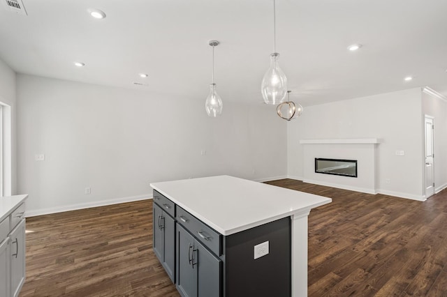 kitchen with pendant lighting, dark hardwood / wood-style flooring, gray cabinets, and a center island