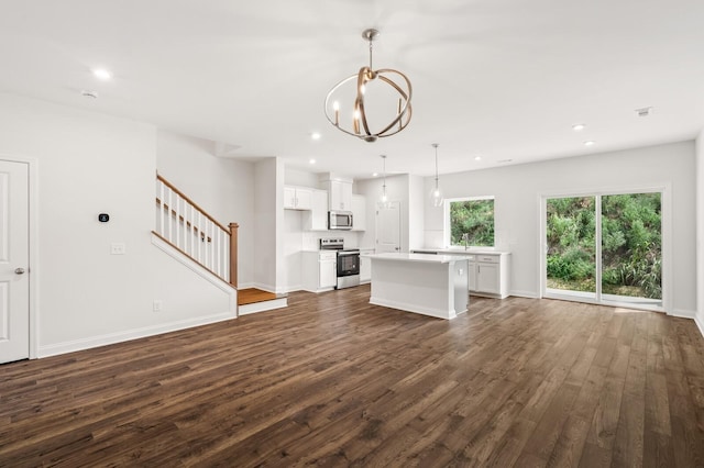 unfurnished living room featuring dark wood-type flooring and an inviting chandelier