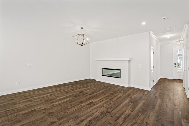 unfurnished living room featuring an inviting chandelier, dark wood-type flooring, and ornamental molding