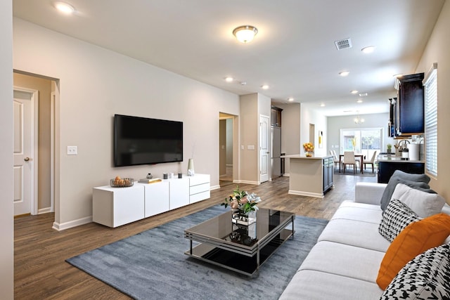 living room with dark hardwood / wood-style flooring and a chandelier