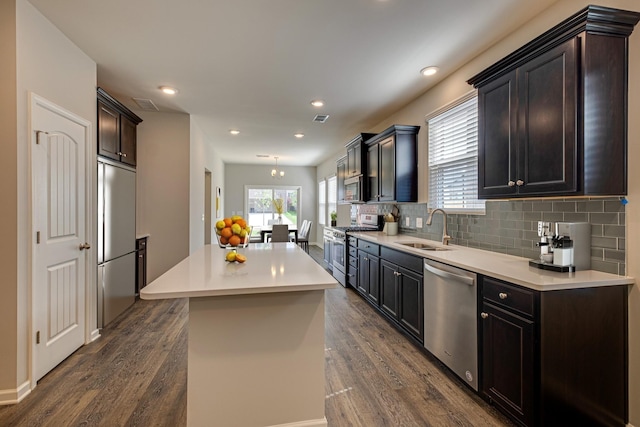 kitchen featuring dark hardwood / wood-style flooring, a center island, sink, and premium appliances