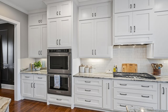 kitchen featuring tasteful backsplash, ornamental molding, appliances with stainless steel finishes, and white cabinets