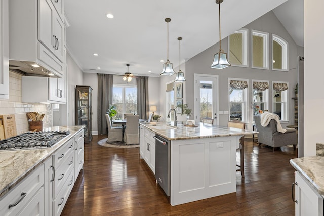 kitchen featuring sink, white cabinetry, light stone counters, stainless steel appliances, and a kitchen island with sink