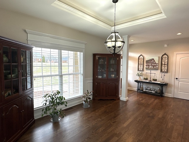 entrance foyer with an inviting chandelier, ornamental molding, dark hardwood / wood-style flooring, and a raised ceiling