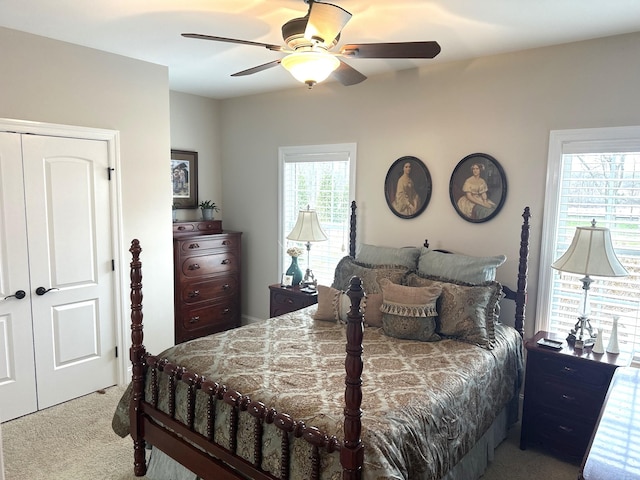 carpeted bedroom with ceiling fan and a closet