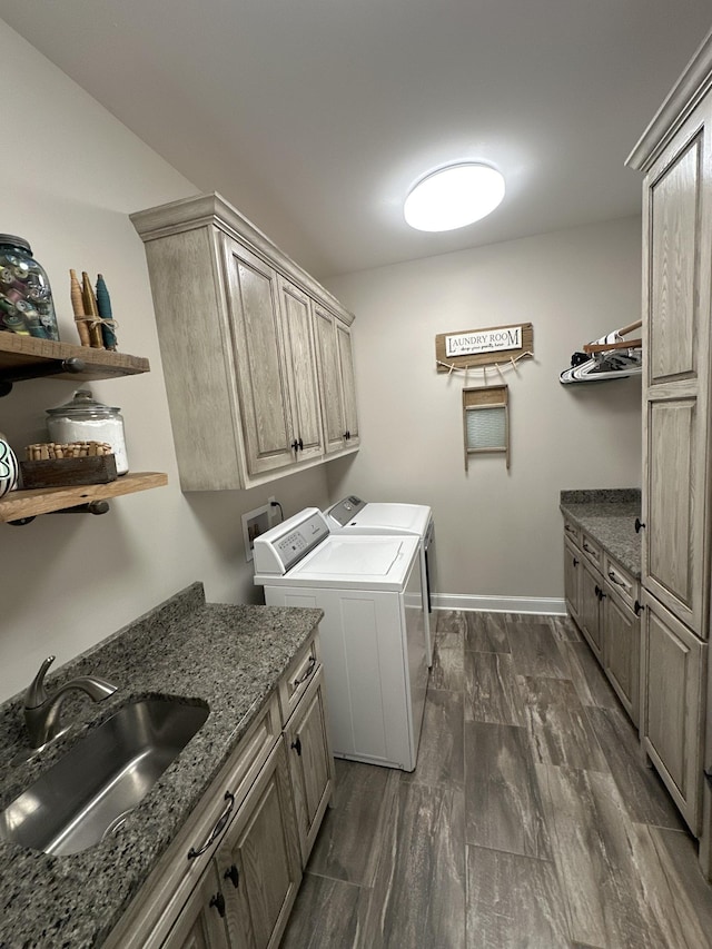 laundry area with cabinets, washer and dryer, sink, and dark wood-type flooring