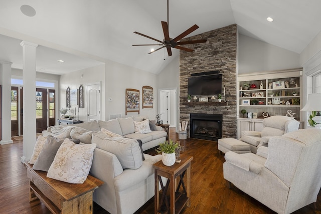 living room with dark wood-style floors, high vaulted ceiling, a fireplace, and decorative columns