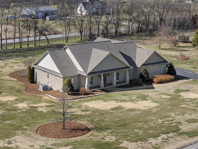 view of front of house featuring central air condition unit, a porch, and a front yard