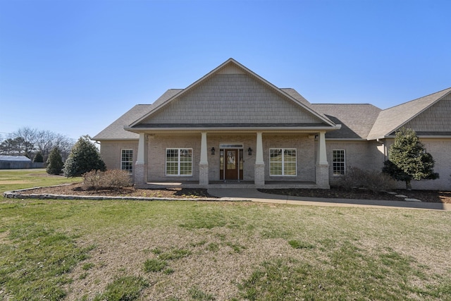 craftsman house with a front lawn and brick siding