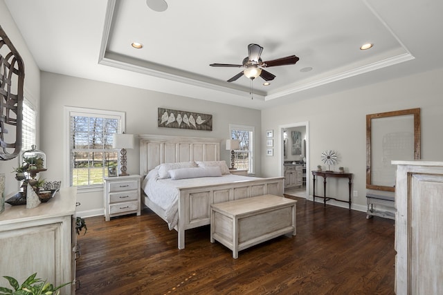 bedroom with a tray ceiling, dark wood-style flooring, and baseboards