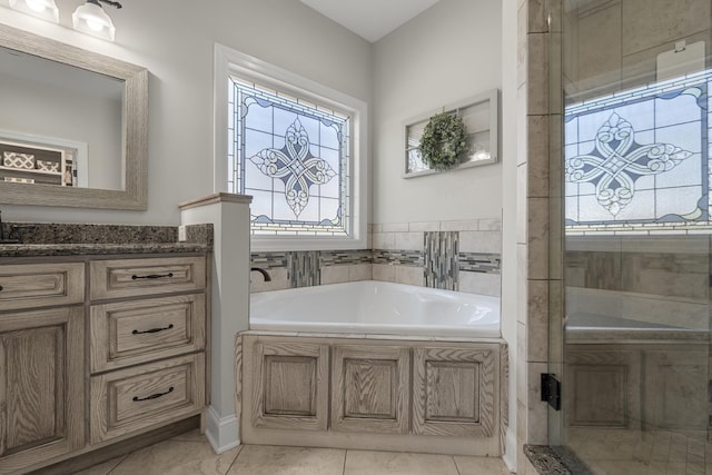 full bathroom featuring vanity, tile patterned flooring, and a bath