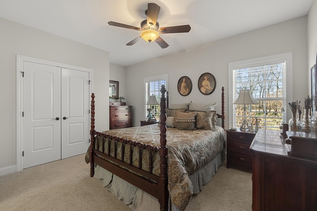 bedroom with light carpet, ceiling fan, and a closet