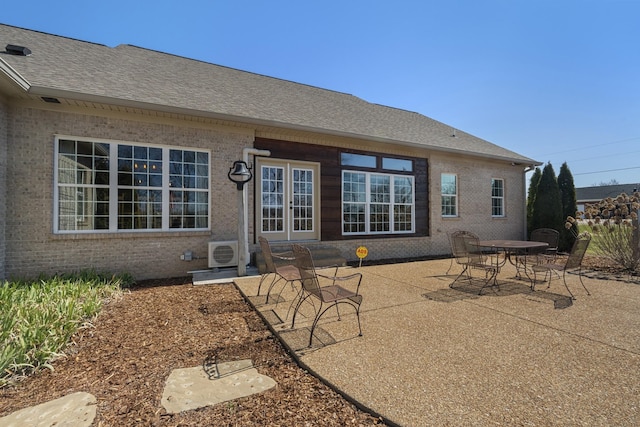 rear view of property featuring french doors, ac unit, a patio area, and brick siding