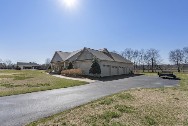 view of home's exterior with a garage, a yard, and aphalt driveway