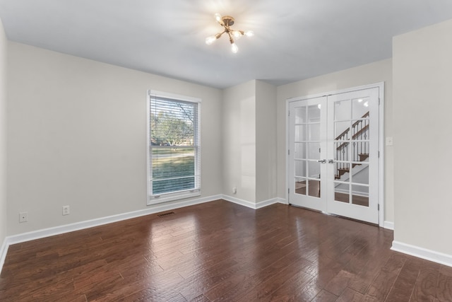 spare room featuring dark wood-type flooring and french doors