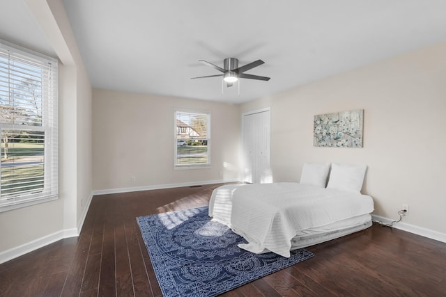 bedroom featuring dark wood-type flooring, a closet, and multiple windows