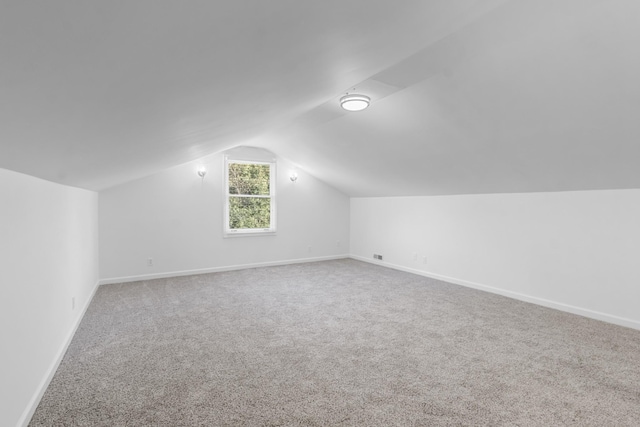 bonus room with lofted ceiling and carpet floors